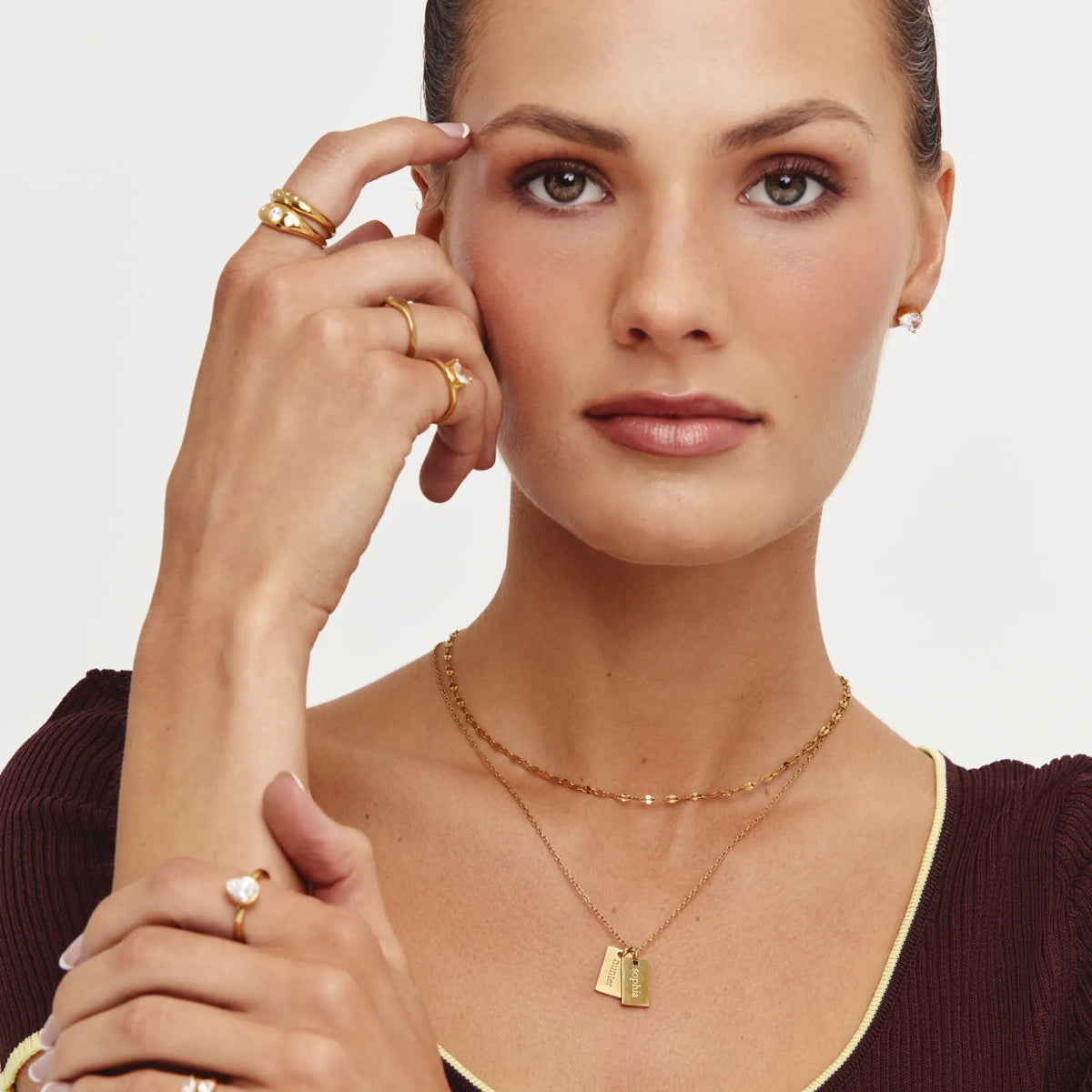 Model wearing the Tag Name Necklace layered with a gold chain
